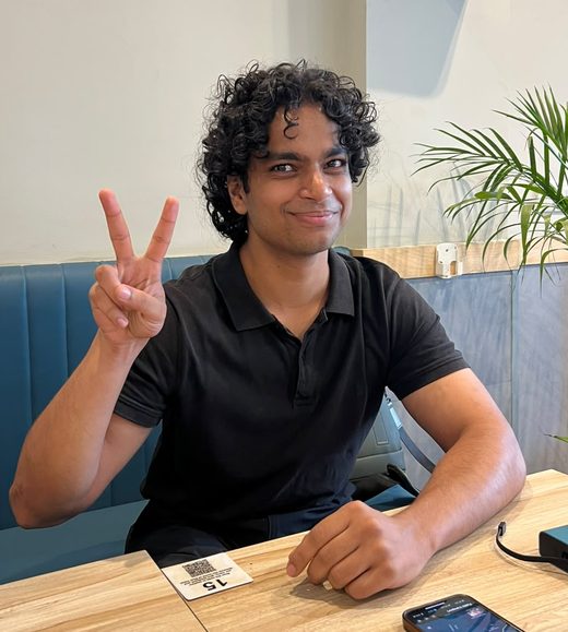 vyom in a cafe, throwing a peace sign